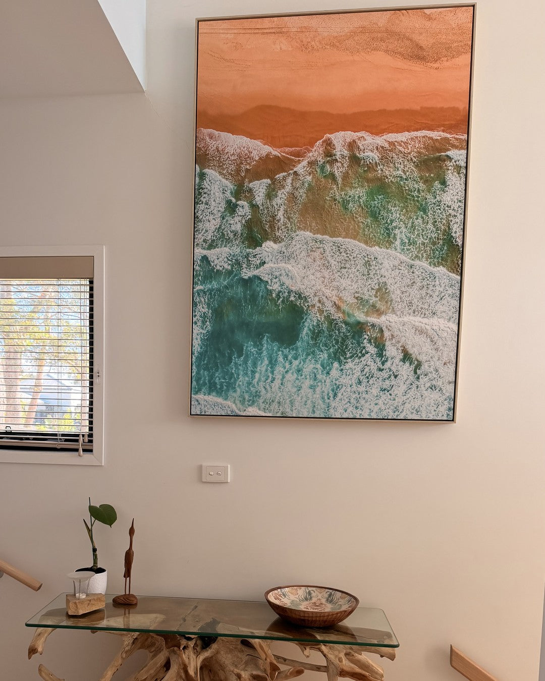 Wanda Wonder print hanging above a driftwood console in a collector's home in Nelson Bay